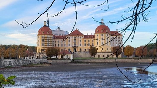 Seniorenfreizeit in Moritzburg Barockschloss mit vier runden Ecktürmen an einem Seeufer im Herbst.