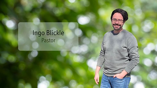 Ingo Blickle Mann mit Brille, grauem Pullover und blauer Jeans steht vor unscharf grünem Hintergrund, links daneben der Text 'Ingo Blickle Pastor'.